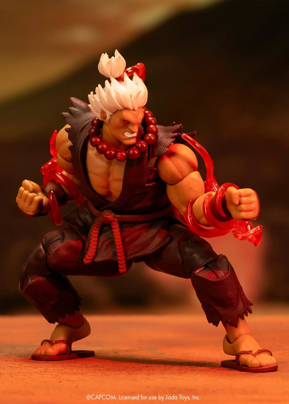 Figurine Akuma Ultra Street Fighter II Jada Toys en position de combat, avec effets d’énergie rouges autour des bras.