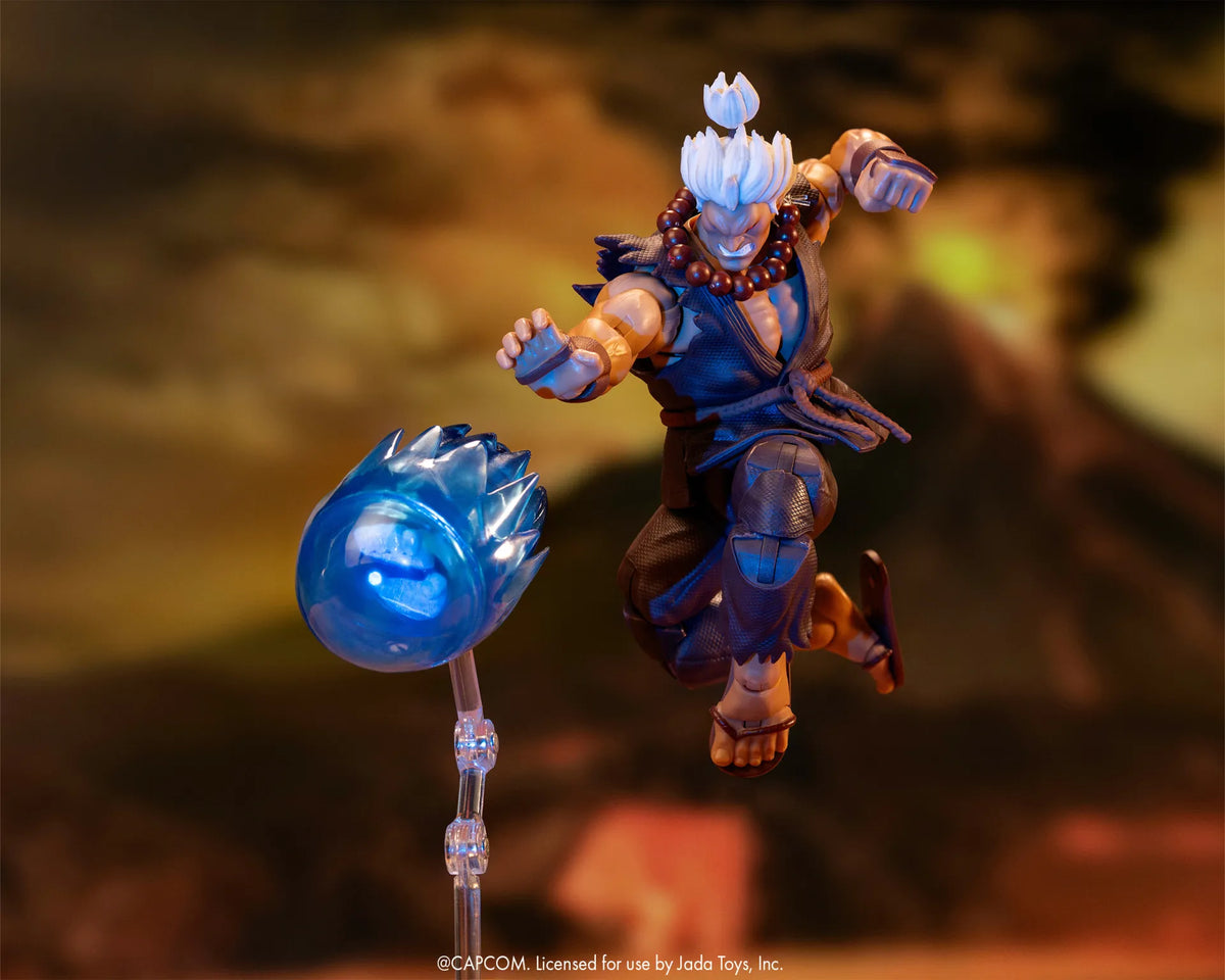 Figurine Akuma Jada Toys en plein saut, main tendue vers un projectile d’énergie bleu posé sur un support transparent